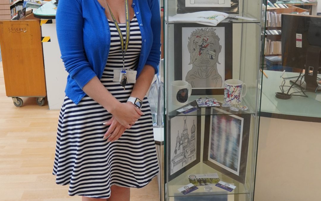 Art Teacher Leanne standing in front of a display case at Lancaster Library