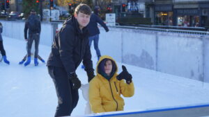 Beaumont student with staff on ice rink skating
